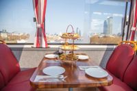 Table and chairs set up in Afternoon Tea Bus in front of London view