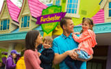 Family with young children stood outside The Furchester Hotel in CBeebies Land Alton Towers Resort