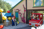 Family on Postman Pat Parcel Post ride driving up to Postman Pat and his cat Jess in CBeebies Land Alton Towers 