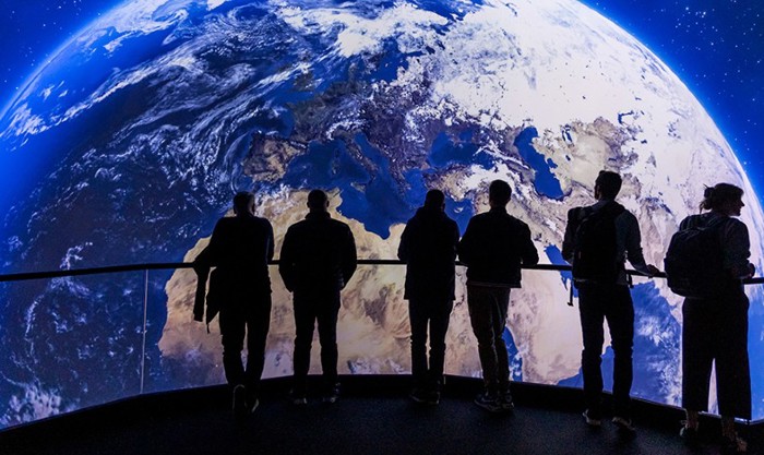 People stood in front of earth screen at BBC Earth Experience