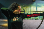 woman holding bow and arrow at Bear Grylls Adventure archery