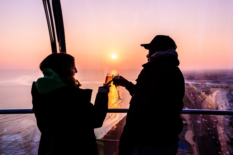 People cheersing glasses at sunset on Brighton i360