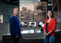 Couple pose in front of a display about Winston Churchill in The Churchill War Rooms museum