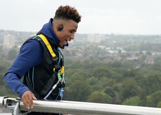 Person in safety harness walking along top of Tottenham Hotspur Stadium at The Dare Skywalk