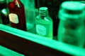 Small alcohol bottles in green light