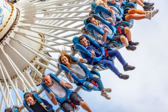 People strapped into Maelstrom ride at Drayton Manor looking excited as they swing through the sky