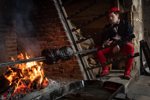 Actor using oven to cook in kitchens at Hampton Court Palace