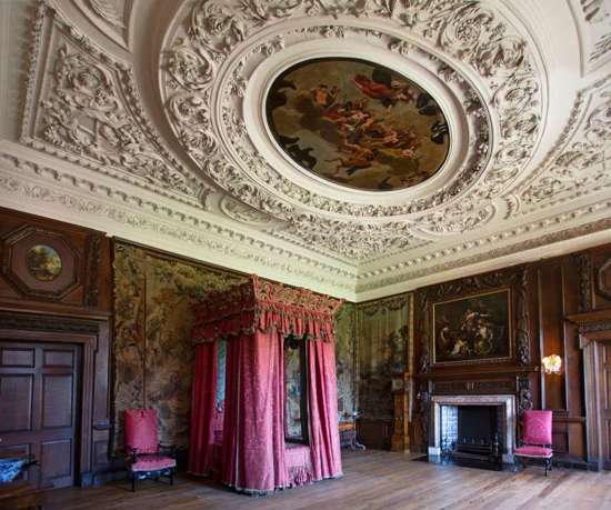 Detailed plaster ceiling and red bed set in King's Bedroom Chamber