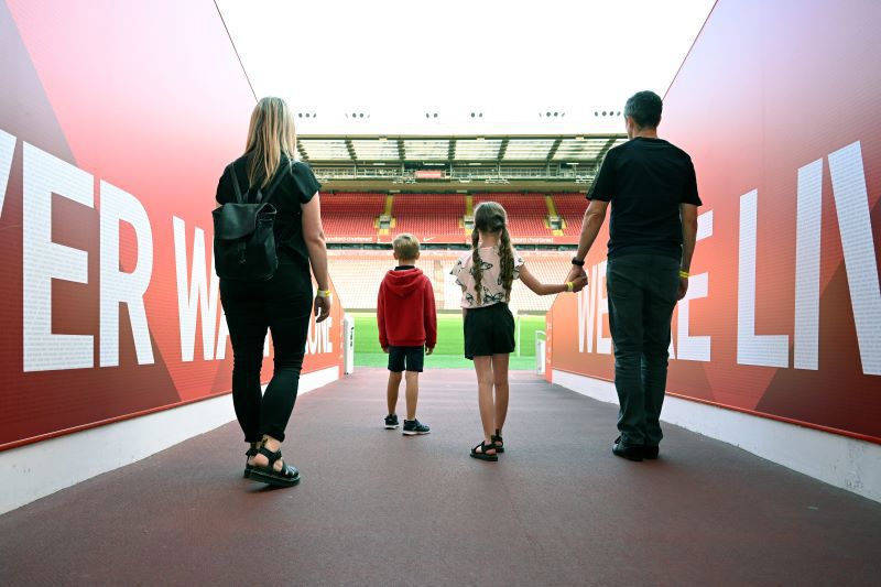 Family walking down pitch walk at Liverpool Stadium Tour