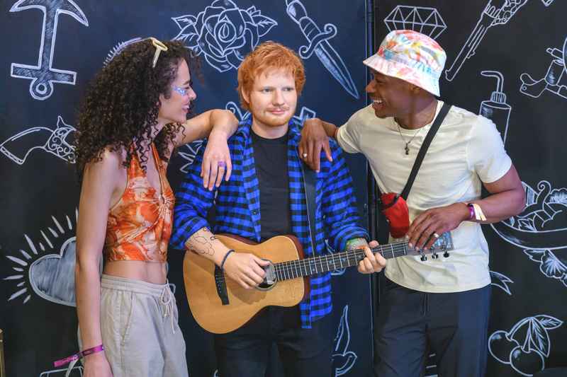 Madame Tussauds London couple enjoying picture with Ed Sheeran