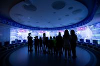 group of people stand in the immersive experience section of the manchester city stadium tour