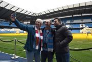 Three people stood at the bottom of stairs at Manchester City Stadium
