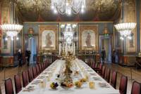 Long table topped with dining set up and chairs lined up in the Banqueting House at Royal Pavilion Brighton