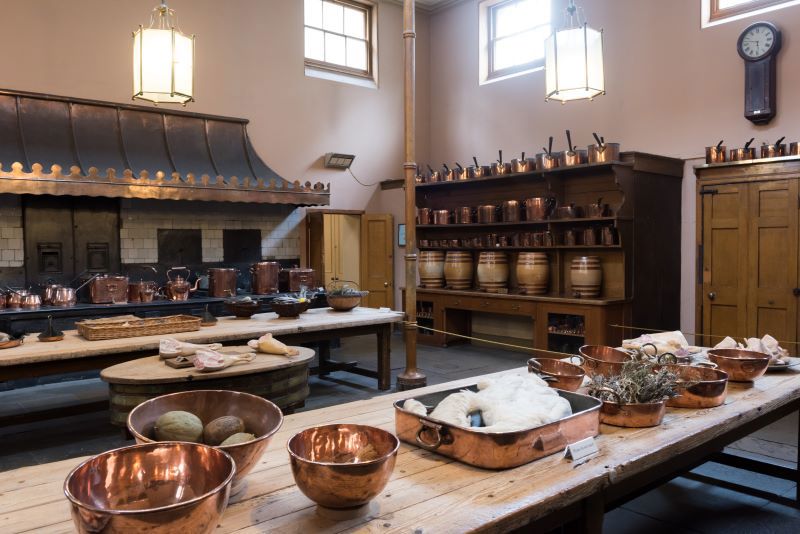 Great Kitchen at Royal Pavilion Brighton with wooden table topped with copper bowls and cooking equipment