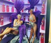 Women with feather headdresses on posing in Supermarket set at Selfie Town Blackpool