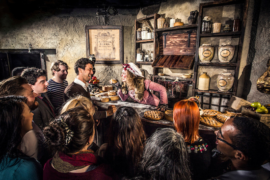Mrs Lovett leaning towards a crowd of visitors in Mrs Lovett's Pie Shop in the London Dungeon