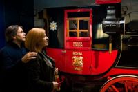 Couple looking at royal post carriage at the postal museum