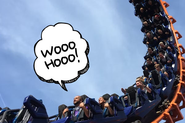 People on a rollercoaster with a doodle speech bubble saying wooo hoo!